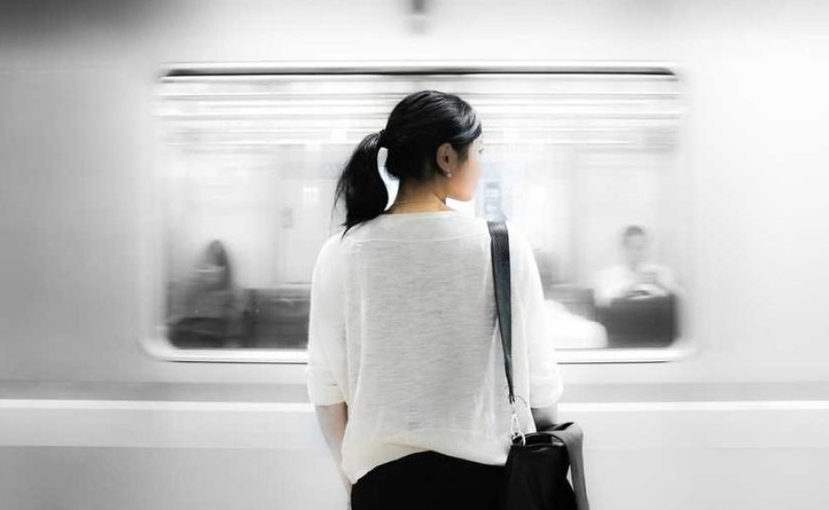 Mensch an vorbeifahrender U-Bahn
